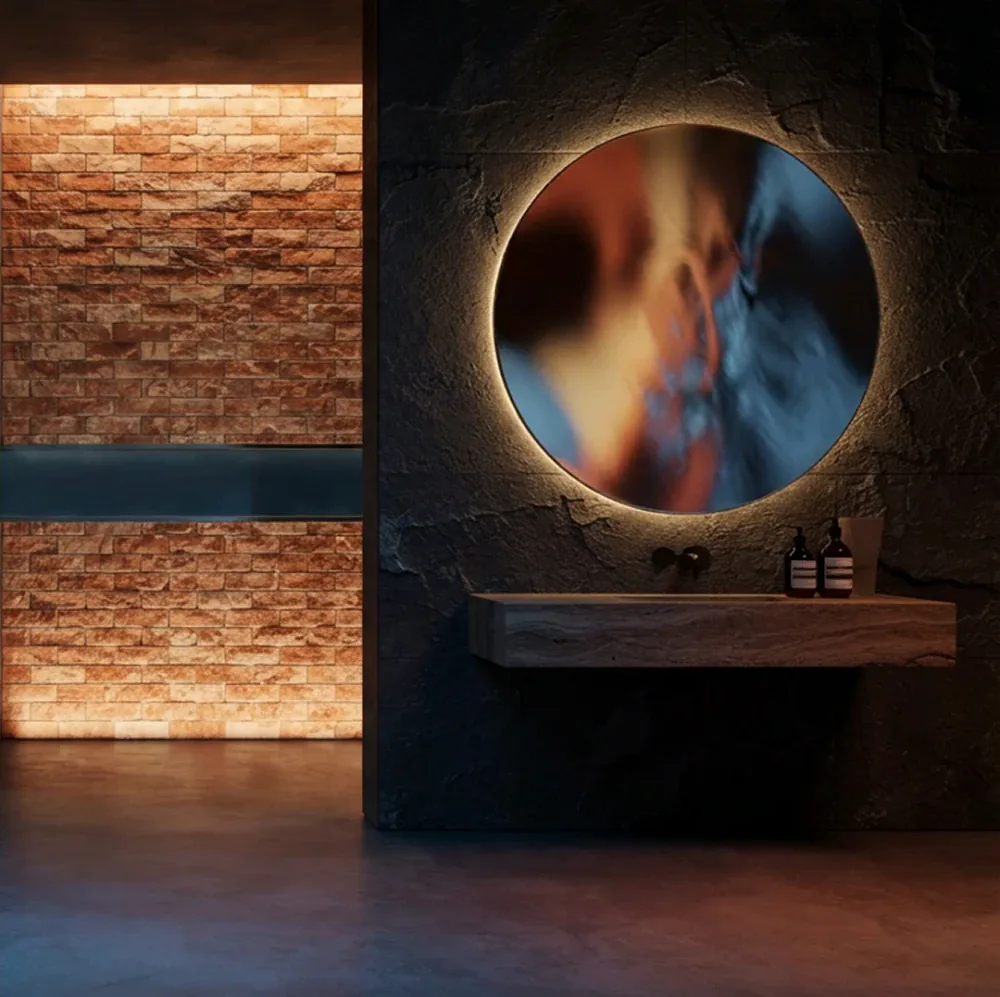 A glowing salt-brick wall beside a stone basin and a round backlit mirror.