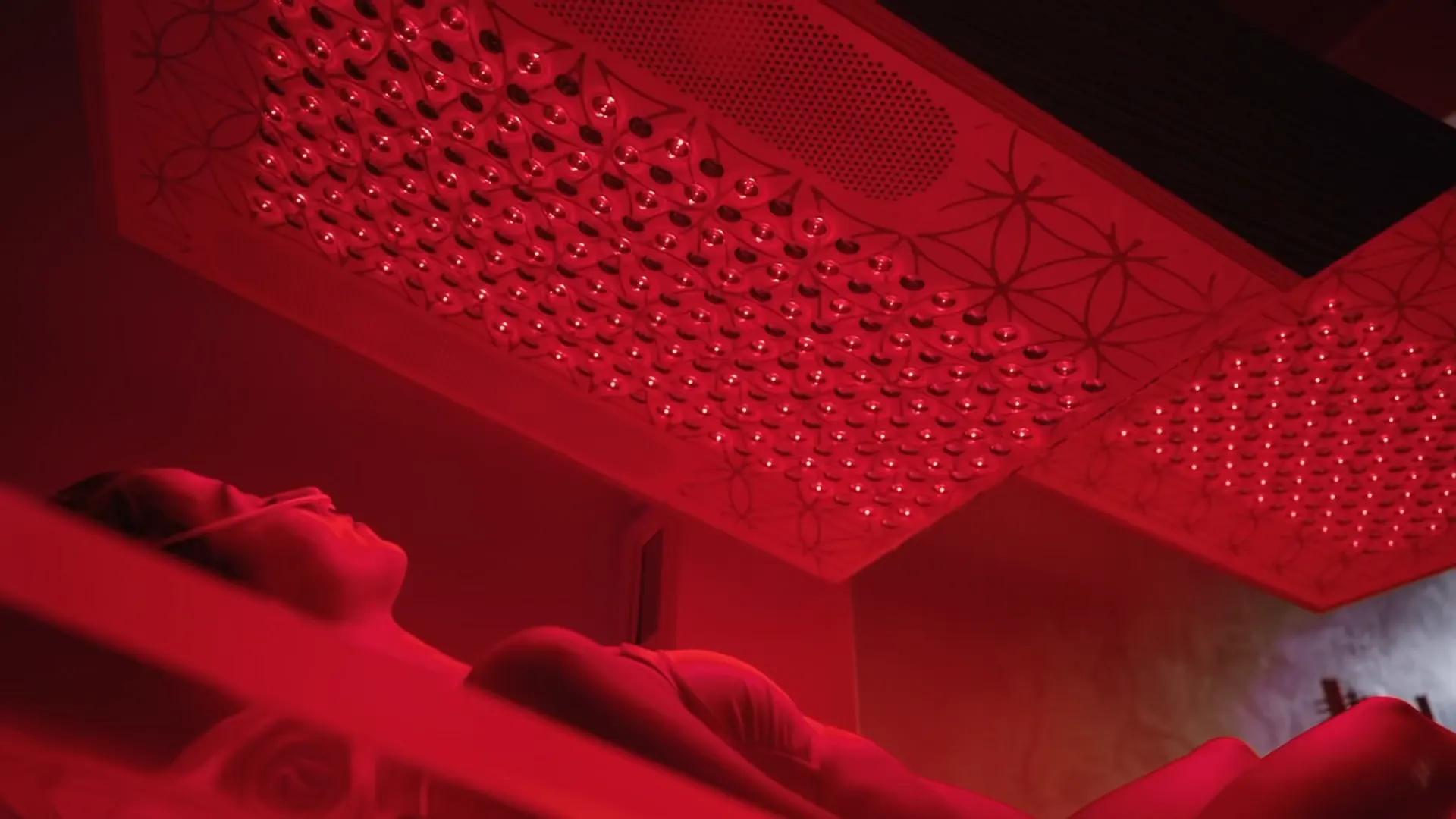 A guest resting beneath a full-spectrum photobiomodulation canopy in an Alteon suite.