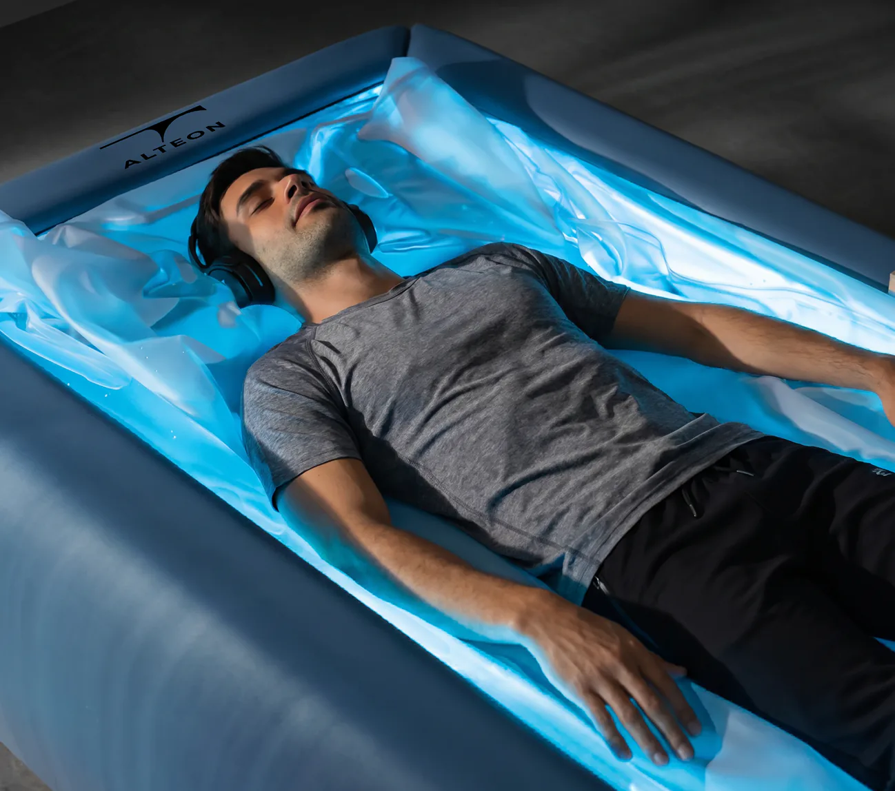A guest resting on a softly lit dry float bed.